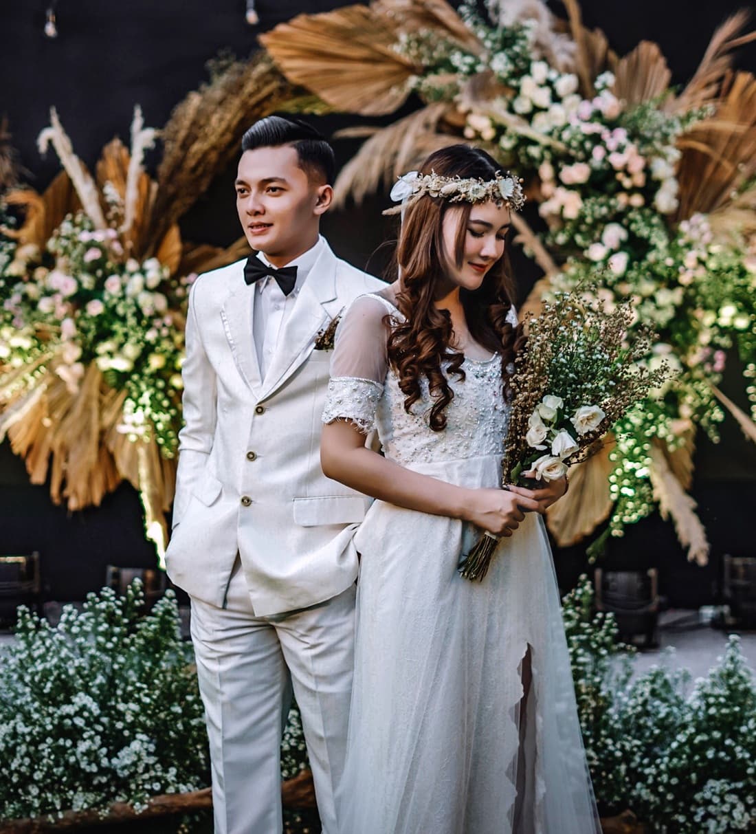 Bride standing by potted plants during Indonesian wedding
